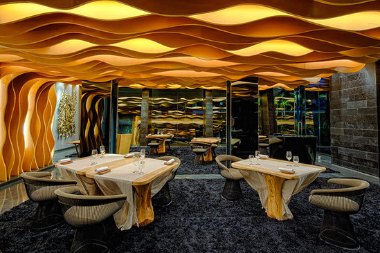 餐厅内部用波浪形的木条装饰了屋顶和墙面，就像是大海的波浪 